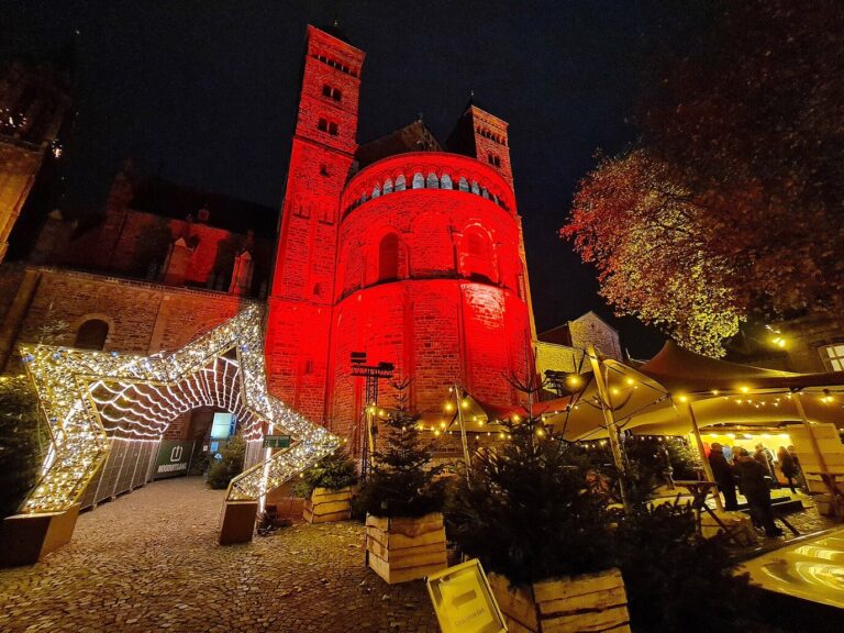 Arche lumineuse en forme d’étoile menant à la basilique Saint-Servais éclairée en rouge, pendant Magisch Maastricht
