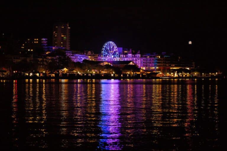 Les quais de Montreux et la grande roue illuminée se reflétant dans le lac Léman, la nuit