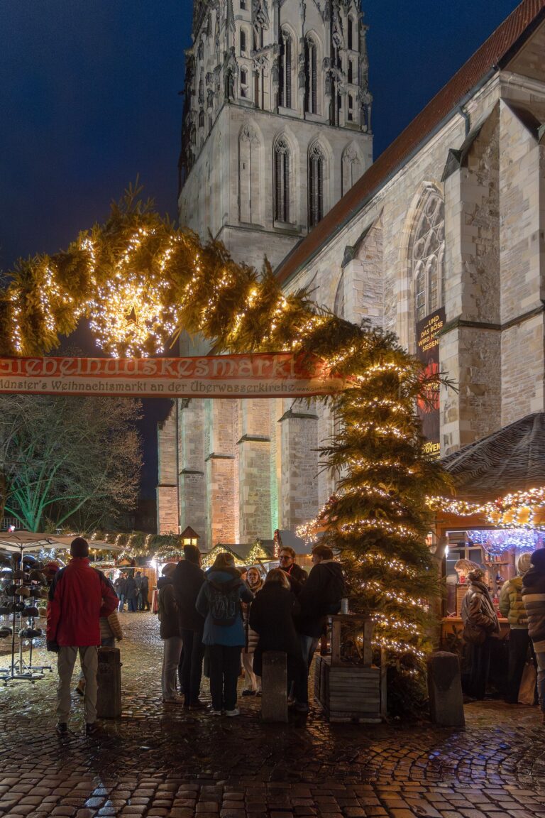 L’arche lumineuse d’entrée du marché de Noël devant la tour de l’église Liebfrauen-Überwasser, le soir