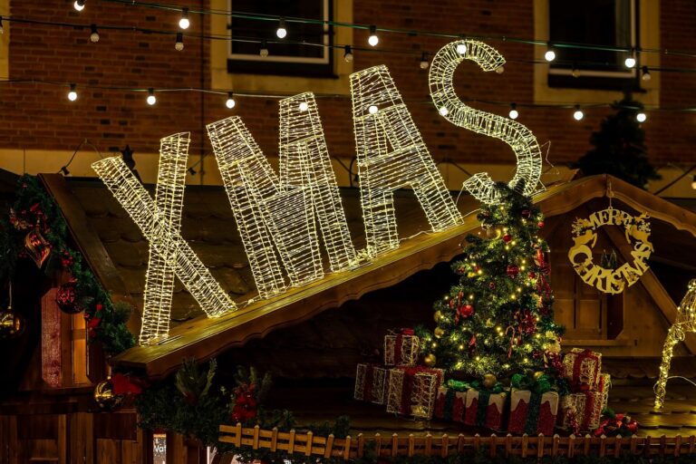 Des lettres lumineuses « XMAS » et un petit sapin décoré sur le toit d’un chalet du marché de l’hôtel de ville, place de la Paix de Westphalie
