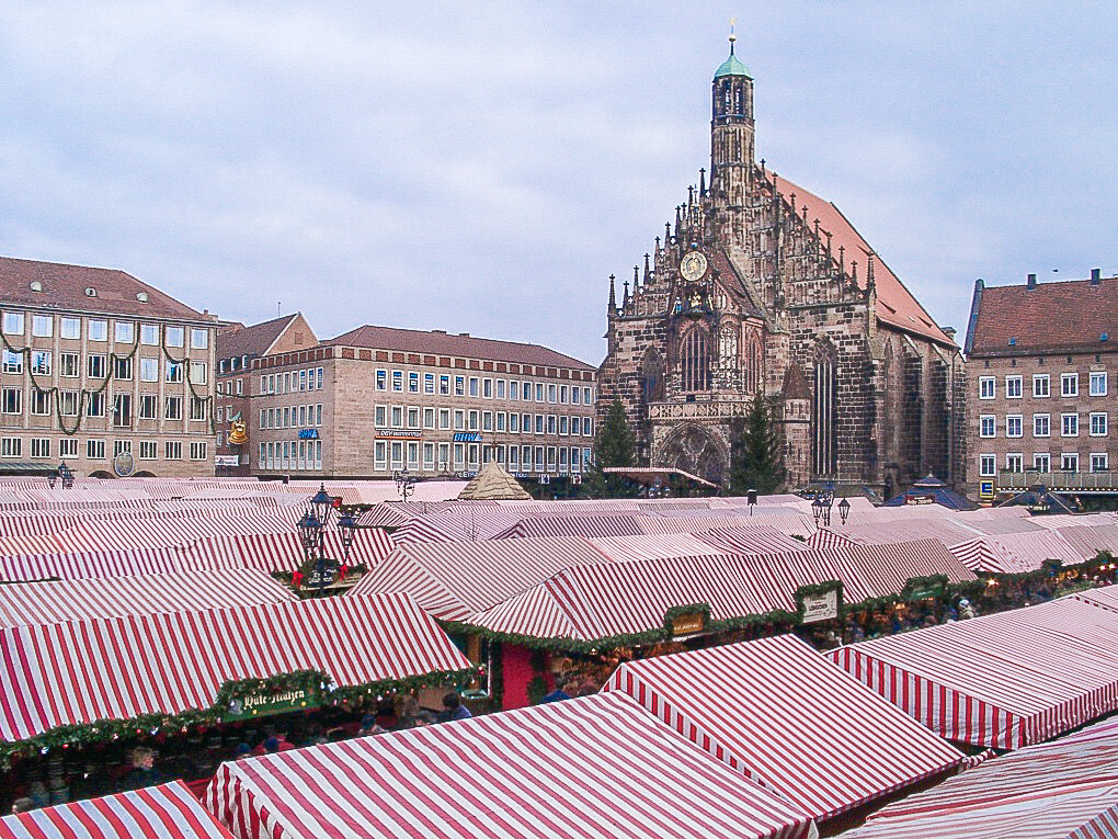 Les toits rayés rouge et blanc des chalets du Christkindlesmarkt vus d’en haut, sur le Hauptmarkt, devant la Frauenkirche