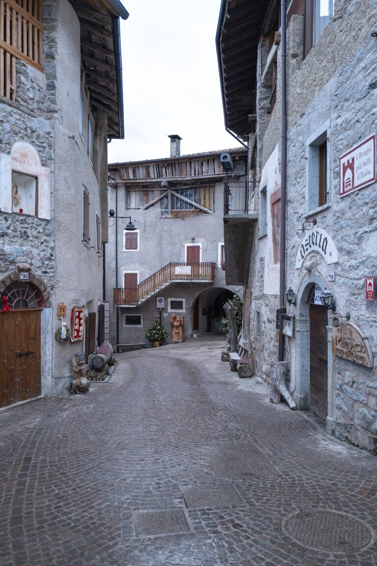 Ruelle de Rango bordée de maisons de pierre aux portes ornées de décorations de Noël