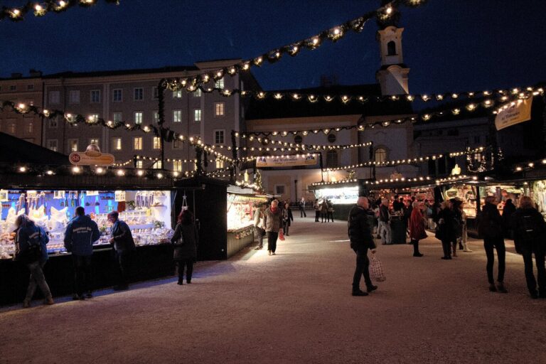 Allées de chalets éclairés sous des guirlandes lumineuses sur la Residenzplatz de Salzbourg, à la nuit tombée