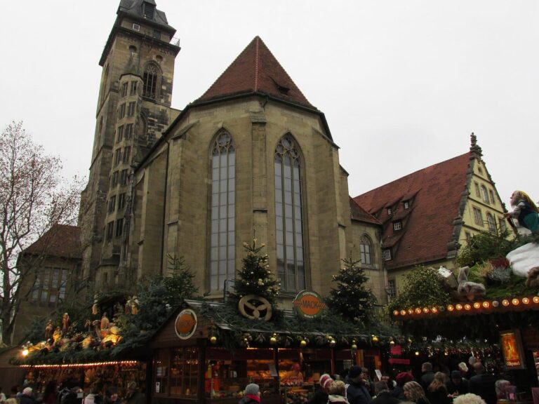 Chalets aux toits décorés de branches de sapin et de figurines devant la Stiftskirche de Stuttgart, par un jour gris de décembre