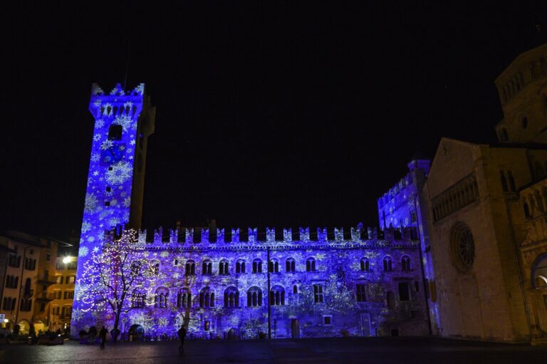 La Torre Civica et le palais Pretorio couverts de projections lumineuses bleues en forme de flocons, la nuit