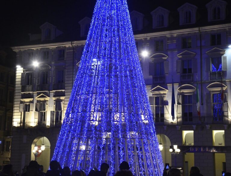 Sapin lumineux bleu devant les façades de la piazza Castello, la nuit