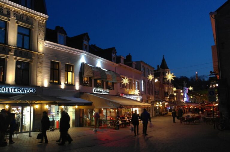 La Grotestraat de Valkenburg à la tombée de la nuit, décorée d’étoiles lumineuses au-dessus des terrasses