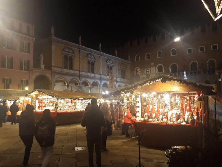Chalets illuminés du marché de Noël sur la piazza dei Signori, devant les palais, la nuit