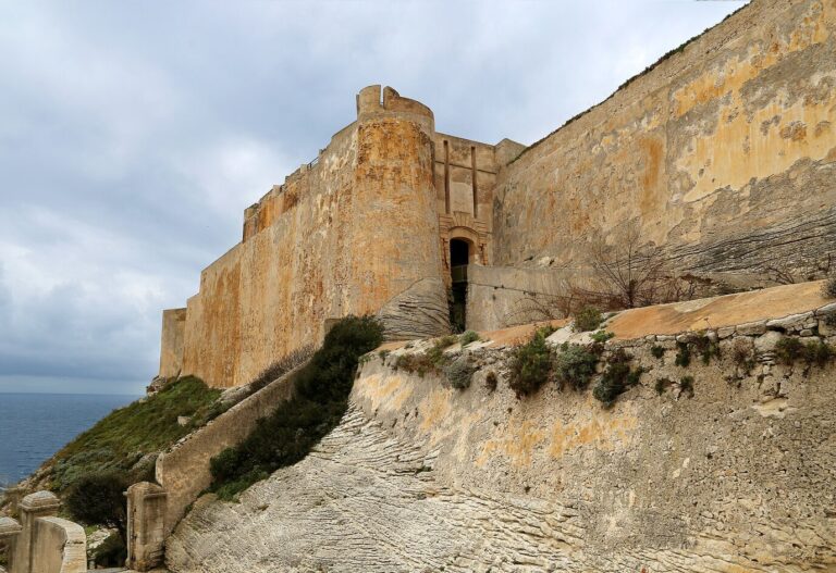 Les remparts et les bastions de la citadelle de Bonifacio près de la porte de Gênes, sous un ciel nuageux d’hiver