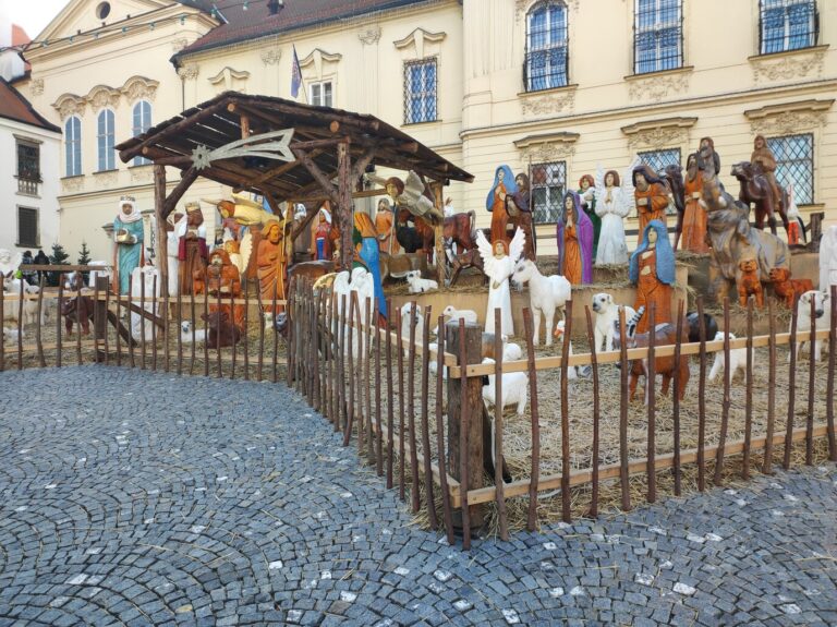 La crèche aux grands santons de bois sculpté de la place Dominikánské à Brno, devant les façades de la place