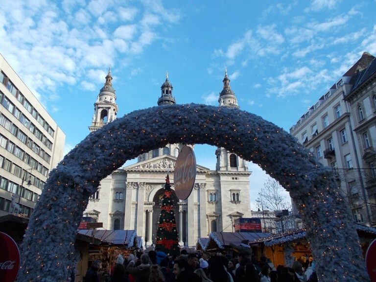 Une arche givrée à l’entrée du marché de Noël de la place Saint-Étienne, avec la basilique et le sapin dans son encadrement, sous un ciel bleu d’hiver