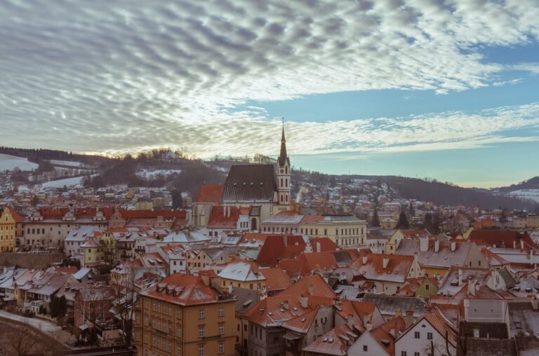 Les toits enneigés de Český Krumlov et le clocher de l’église Saint-Guy, vus depuis le château, en hiver