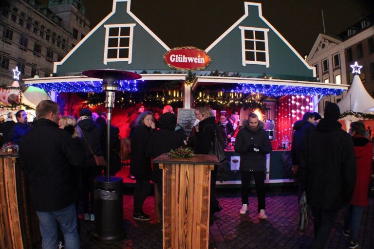 Un chalet à Glühwein aux toits verts du marché de Noël de Nytorv, de nuit, sous des guirlandes bleues