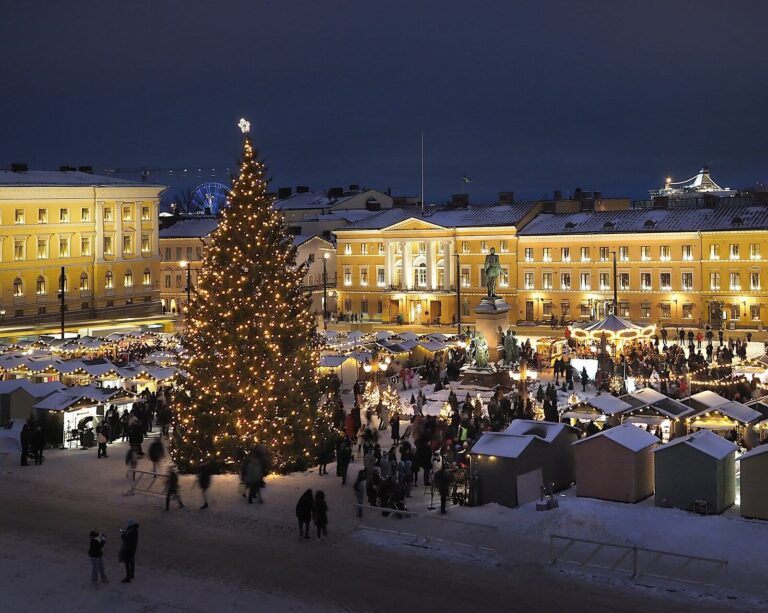 La place du Sénat d’Helsinki vue d’en haut au soir, avec son grand sapin illuminé et les chalets du marché de Noël sous la neige