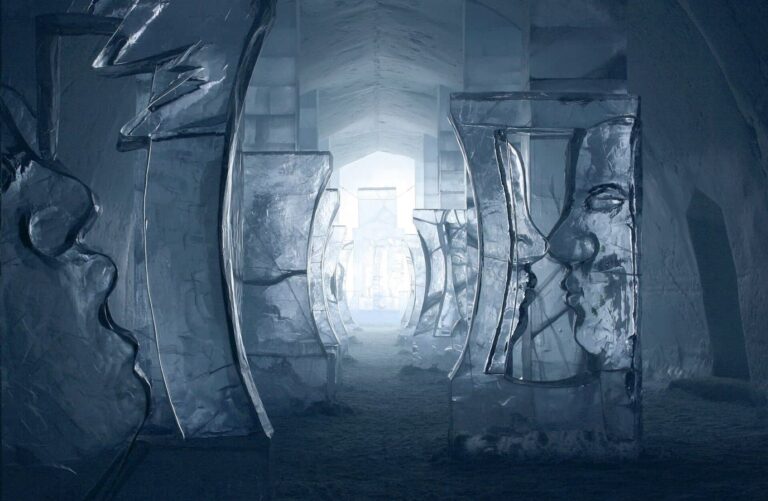 Le grand hall de l’Icehotel avec deux visages de glace face à face et un couloir lumineux au fond