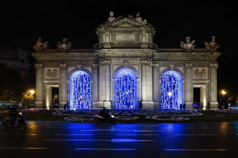 La Puerta de Alcalá illuminée pour Noël, ses trois arches centrales remplies de motifs lumineux bleus, de nuit