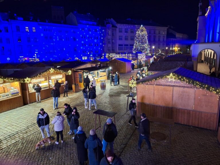 Allée de chalets du marché de Noël d’Olomouc menant au sapin illuminé, de nuit