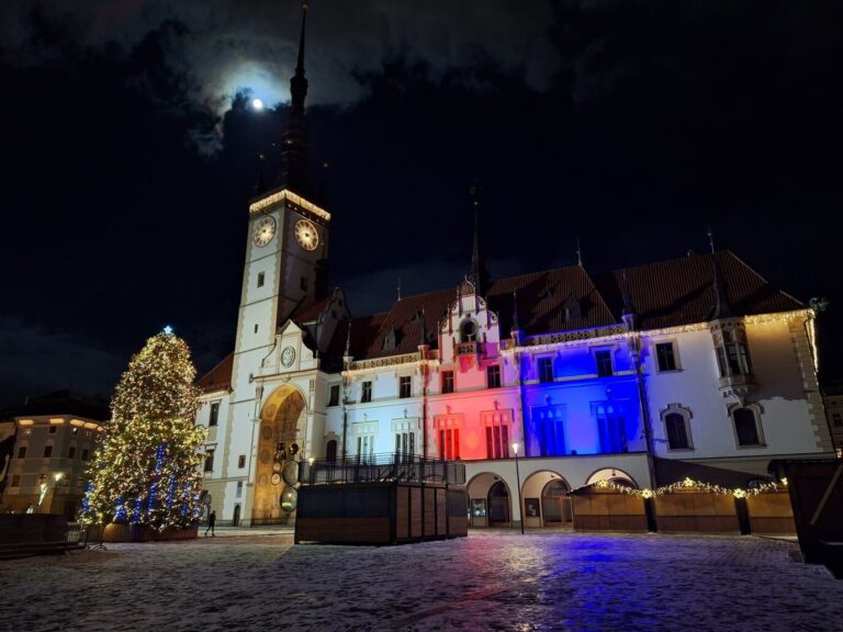 L’hôtel de ville d’Olomouc illuminé aux couleurs tchèques et le sapin de Noël sur la place Horní enneigée, de nuit