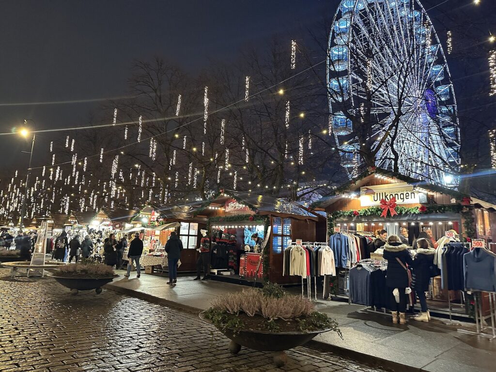 Chalets du marché de Noël et grande roue illuminée le long de Karl Johans gate, à Oslo, de nuit