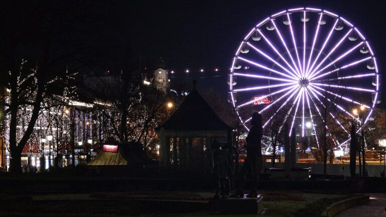 La grande roue violette du marché de Noël d’Oslo, de nuit, devant un kiosque à musique