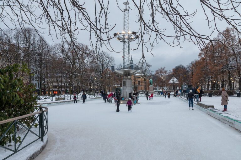Des patineurs sur la glace de Spikersuppa sous la neige, entre les arbres de Karl Johans gate