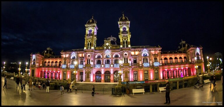 L’hôtel de ville de Saint-Sébastien, ancien casino aux deux tours, éclairé de rose et de blanc pour Noël, vu de nuit depuis les jardins d’Alderdi Eder