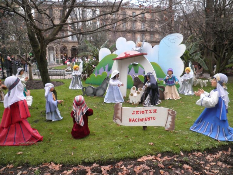 La crèche en plein air d’un jardin du centre de Saint-Sébastien : grands santons de bergers et d’anges autour de l’étable, devant un panneau « Jaiotza Nacimiento »