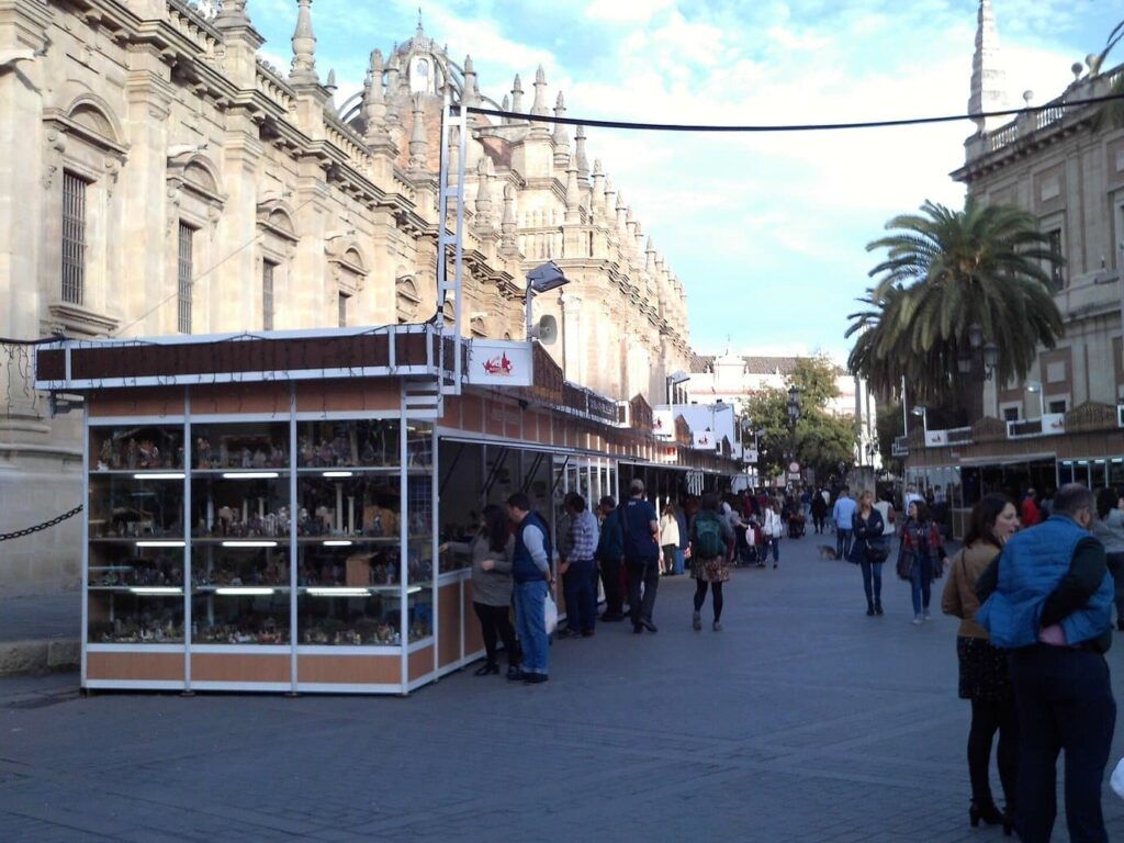 Les vitrines de la Feria del Belén de Séville sur l’avenida de la Constitución, entre la cathédrale et l’Archivo de Indias, par un après-midi ensoleillé