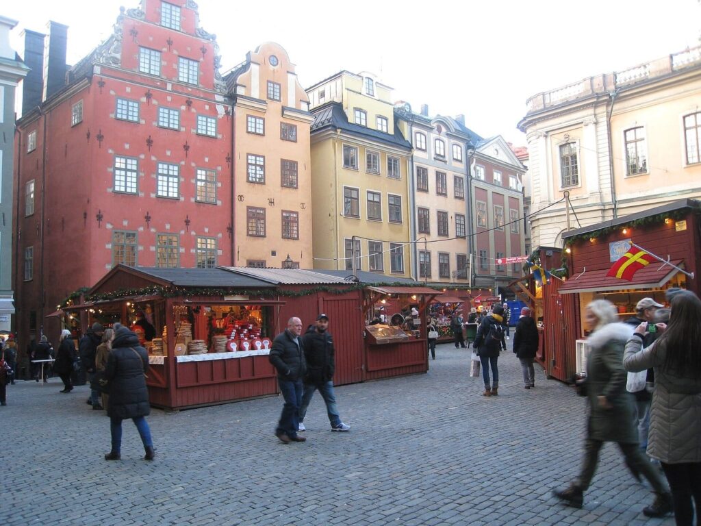 La place Stortorget vue en grand angle, avec les chalets rouges du marché de Noël et les façades colorées de la vieille ville de Stockholm