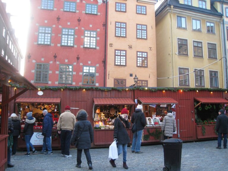 Une rangée de chalets rouges devant les façades rouge et jaune de la place Stortorget, à Gamla stan