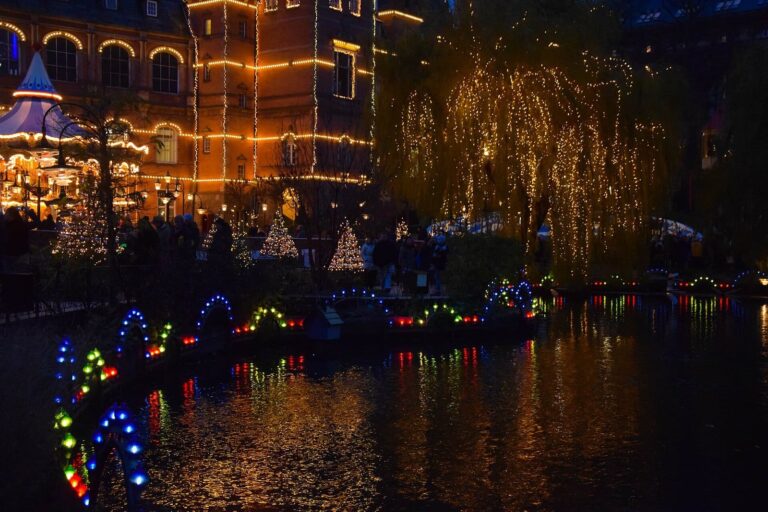 Le lac de Tivoli et ses saules aux guirlandes lumineuses, reflets colorés sur l’eau, au crépuscule