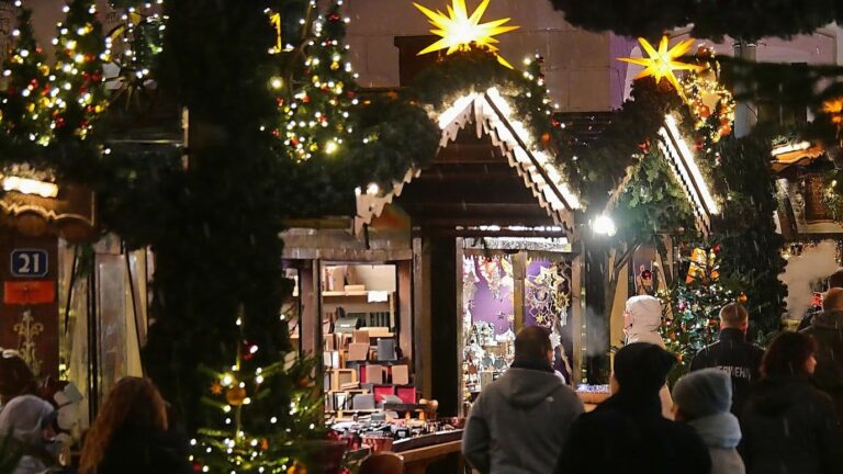 Chalets en bois décorés de branches de sapin, d’étoiles lumineuses et de guirlandes, la nuit sur le marché de Noël de Trèves