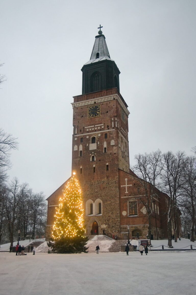 La cathédrale de Turku et son sapin de Noël illuminé de guirlandes jaunes, sur la neige, en fin de journée