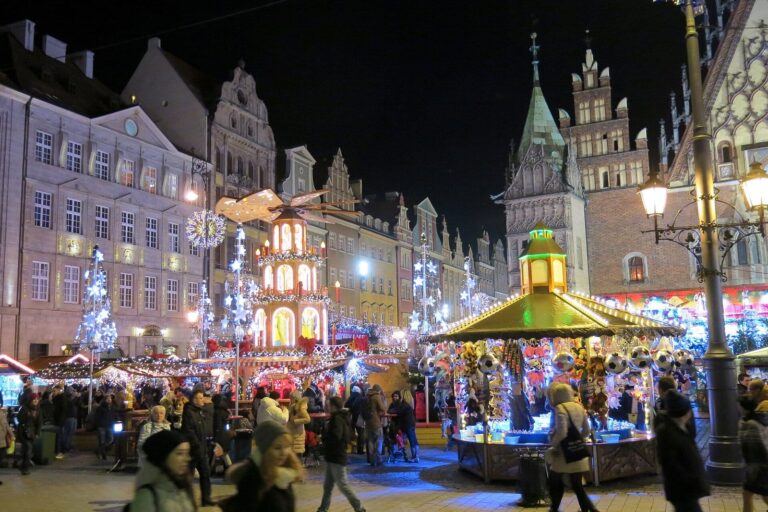 Le Rynek de Wrocław de nuit avec la pyramide de Noël et le carrousel au milieu de la foule
